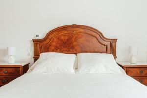 ein Bett mit einem Kopfteil aus Holz und zwei Nachttischen in der Unterkunft Casa Cuco in Corejido