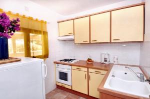 a kitchen with a sink and a white refrigerator at Maison de 3 chambres avec vue sur la mer piscine partagee et jardin clos a Cargese in Cargèse