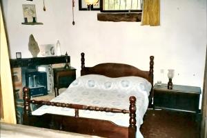 a bedroom with a wooden bed and a fireplace at Maison de 3 chambres avec vue sur la mer piscine partagee et jardin clos a Cargese in Cargèse