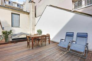una terrazza in legno con tavolo e 2 sedie di Cocoon with AC & Private Terrace - Republique a Parigi