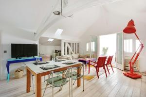 un soggiorno con tavolo e sedie rosse di Cocoon with AC & Private Terrace - Republique a Parigi