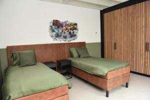 a bedroom with two beds and a cabinet at Villa met 13 slaap plaatsen in Alphen