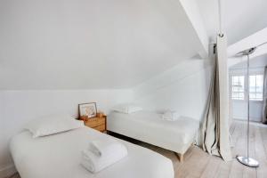 2 letti in una camera con pareti bianche di Cocoon with AC & Private Terrace - Republique a Parigi