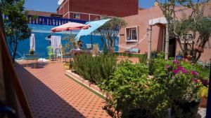 a patio with tables and umbrellas and plants at Villa salma in Oualidia