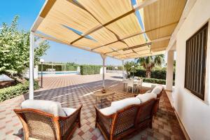 d'une terrasse avec des chaises en osier et un parasol en bois. dans l'établissement Villa Giada, à Francavilla Fontana