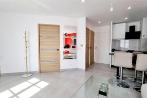 a living room with a kitchen with a door and chairs at Disney Luxury Studio in Serris