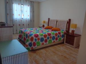 ein Schlafzimmer mit einem Bett mit einer bunten Decke in der Unterkunft Apartamento Albufeira 6 B in Albufeira