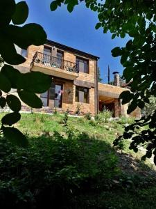 a large brick house with a balcony in a yard at Mountain View Guesthouse in Dilijan