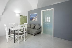 a living room with a couch and a table and chairs at Corrado Caldera Apartments in Fira