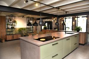 a kitchen with a large island with a sink at Villa met 13 slaap plaatsen in Alphen