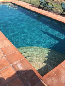 una piscina de agua azul y 2 sillas en Paraje Navazos en Gavilanes