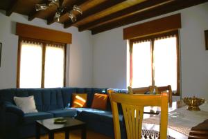 a living room with a blue couch and a table at Casa con patio en Nueva de Llanes - El Churru in Nueva de Llanes +10 photos