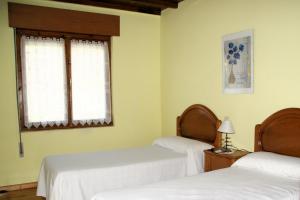 a room with two beds and a window at Casa con patio en Nueva de Llanes - El Churru in Nueva de Llanes