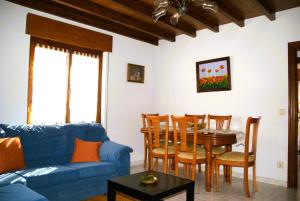 a living room with a blue couch and a table at Casa con patio en Nueva de Llanes - El Churru in Nueva de Llanes