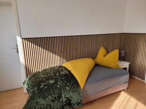 a bedroom with a bed with yellow pillows at Carl-Schmäcke-Straße 7 in Neuenhagen