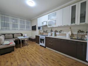 uma grande cozinha e sala de estar com um sofá em Юнусабад шахристан люкс em Yunusobod