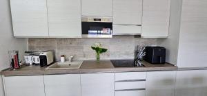 a kitchen counter with a sink and a microwave at Serendipity, La Caletta in La Caletta