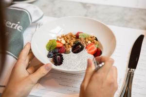 a person eating a bowl of cereal and fruit at TORTUE Hamburg in Hamburg