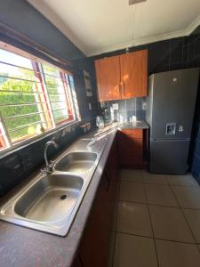 uma cozinha com 2 lavatórios e um frigorífico em The Lake Villa em Benoni