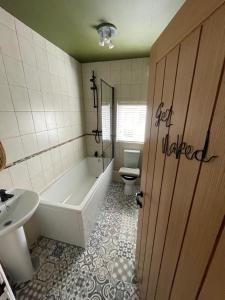 y baño con bañera, aseo y lavamanos. en Overleigh Cottage, with optional Hot Tub hire, en Chester