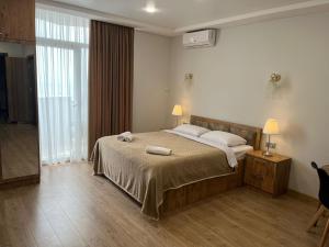 バトゥミにあるHoliday Premium Apartments Batumiのベッドとタオル2枚のある寝室