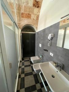 ポリニャーノ・ア・マーレにあるLorèのバスルーム(トイレ2つ、シンク付)