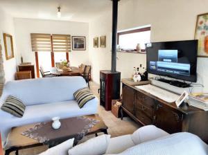 uma sala de estar com um sofá e uma televisão de ecrã plano em 3 bedrooms house with private pool jacuzzi and enclosed garden at Donji Lapac em Donji Lapac