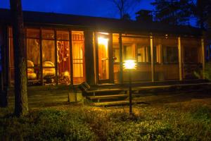 una casa con una luz delante de ella por la noche en VESI - The White Blue Wilderness Lodge en Inari