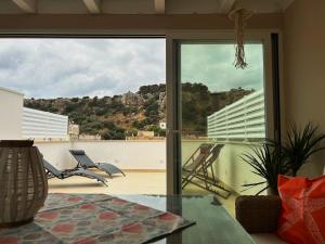 a room with a glass table and a view of a balcony at Memo - Mediterranean Emotions in San Vito lo Capo