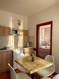 cocina con mesa de madera y sillas blancas en Villa Pestani en Peštani