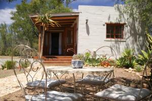 una mesa y sillas frente a una casa en Karoo Feels en Prince Albert