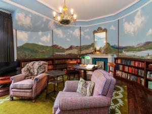 a living room with a large mural of mountains on the wall at Dalvorar - Mar Lodge Estate in Ballater