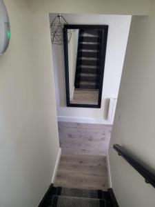 a hallway with a mirror and a stairway at 360 Town Stay Apartments & Studios in Dungarvan