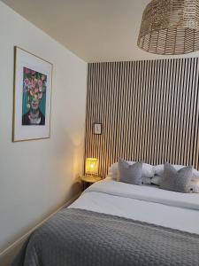 ein Schlafzimmer mit einem Bett und einem Gemälde an der Wand in der Unterkunft 360 Town Stay Apartments & Studios in Dungarvan