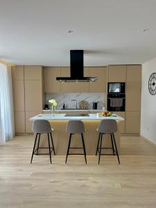 a kitchen with two bar stools and a kitchen island at Courtyard Villa, Aleksandrovo in Aleksandrovo