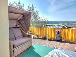 una silla de mimbre sentada en una terraza con parrilla en Make yourself at home en Vaihingen an der Enz