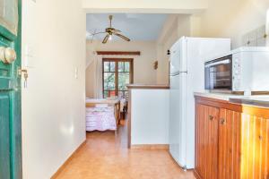 a kitchen with a white refrigerator and a table at Castellos Bellos Studio 1 in Marathias