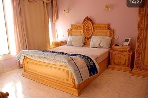 Un dormitorio con una cama grande con marco de madera. en Villa with Private Pool, en Hurghada