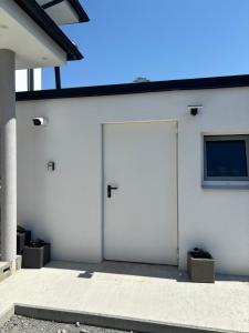 a white garage with a door and a window at Eco Overnight Inn 