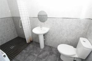 een badkamer met een toilet, een wastafel en een spiegel bij Hawkhill House in Leeds