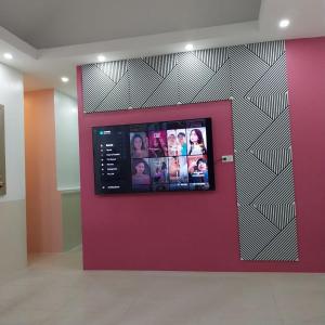 Una pared con TV con fotos. en PrimeRose Residences, en Lapu Lapu City
