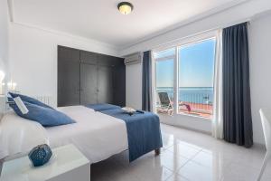 a bedroom with a large bed and a large window at Hotel Vibra Vila in Ibiza Town