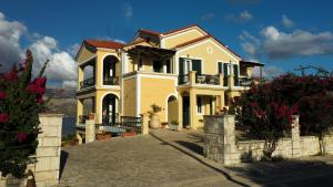 a large yellow house with a driveway at Remenata in Lixouri