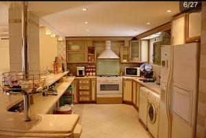cocina grande con armarios de madera y nevera blanca en Villa with Private Pool, en Hurghada