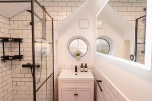 a white bathroom with a sink and a shower at Charming 2-Bed Cottage in Mickle Trafford- Sleeps 6 - Pet Friendly - Near Chester 