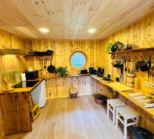 a kitchen with wooden walls and wooden floors at Baltic Sea Cottage in Jūrmala