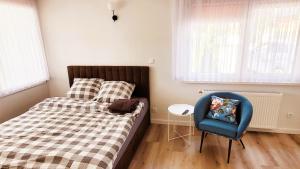 um quarto com uma cama e uma cadeira azul em apartamenty nad jeziorem em Turawa