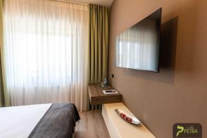 ein Hotelzimmer mit einem Bett und einem Spiegel in der Unterkunft Vila Petra in Cristian