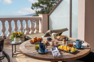 a table with breakfast food on top of a balcony at Tiara Miramar Beach Hotel & Spa in Th&eacute;oule-sur-Mer