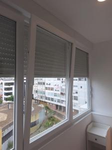 Habitación con 3 ventanas con persianas. en Lisbon South Bay Rooms 2, en Almada